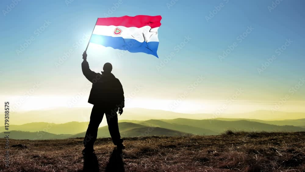 Successful silhouette man winner waving Paraguay flag on top of the mountain peak, Cinemagraph LOOP background