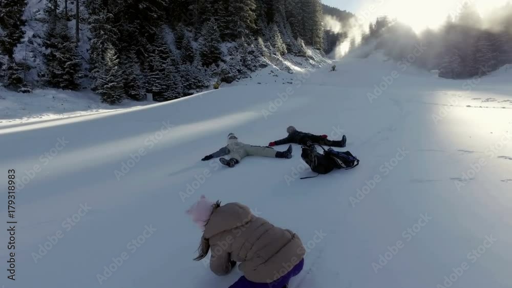 Three little kids playing outdoors on snow ski slope and having fun. Active leisure with children in winter on cold days.