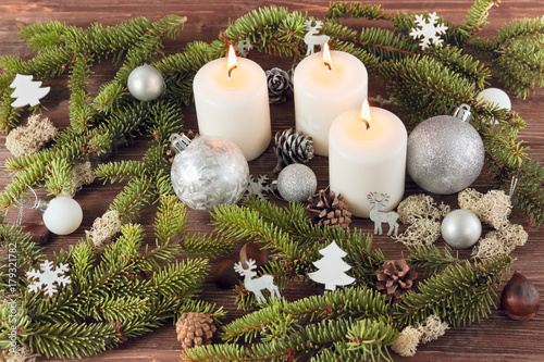 Candles, spruce branches, Christmas decorations on a wooden background