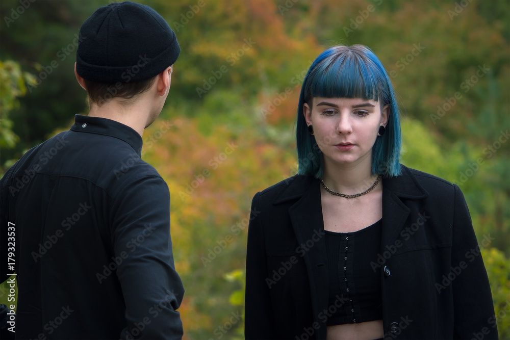 Gothic couple love story. Man and blue hair girl at black clothes at green river background Gothic couple love story. Man and blue hair girl at black clothes at green river background