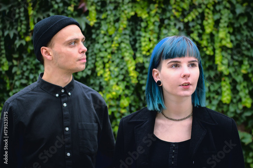 Gothic couple love story. Man and blue hair girl at black clothes at green river background