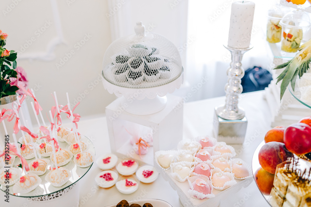 Wedding reception dessert table with delicious decorated white cupcakes with frosting