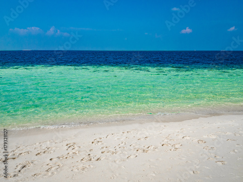 Tropical island vacation image  white sand beach and turquoise blue crystal clear water  Maldives