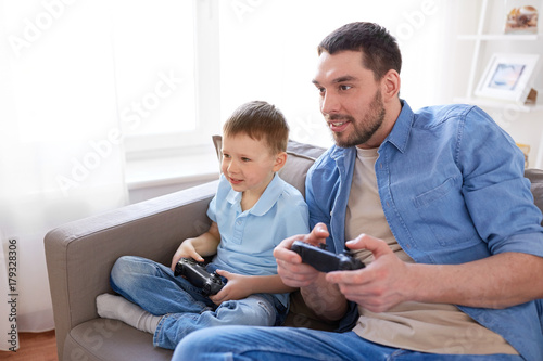 father and son playing video game at home