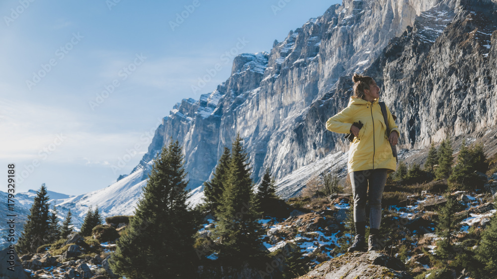 Obraz premium Attractive female hiking in high mountains, French Alps, mountain peaks covered with snow in the background