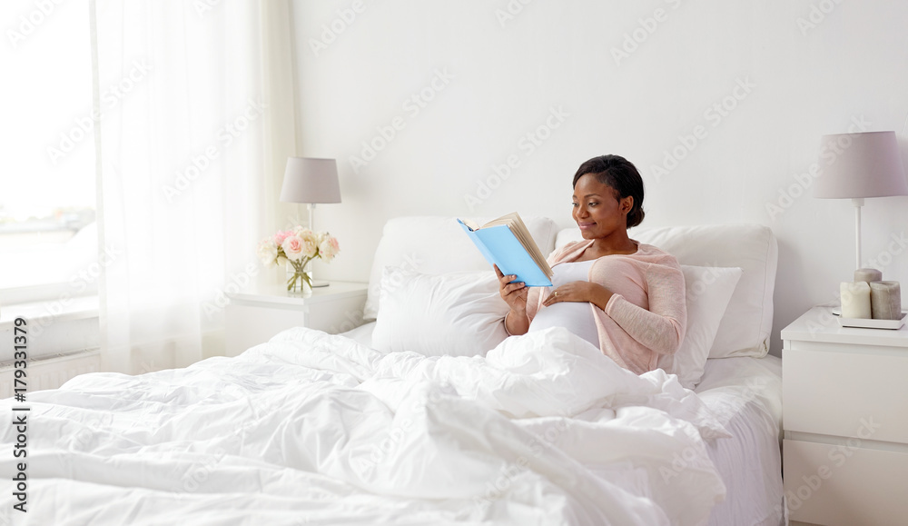 happy pregnant african woman reading book at home happy pregnant african woman reading book at home