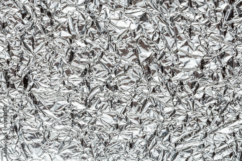 Crumpled shiny metal foil texture or background Crumpled shiny metal foil texture or background