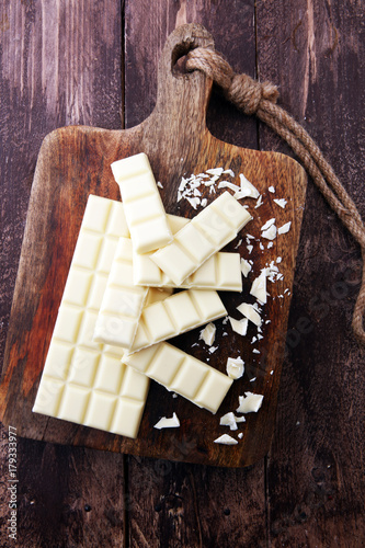 white chocolate bars and white choco pieces on wood.