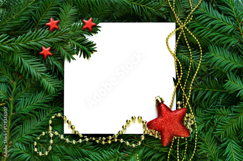 Creative background of pine branch with white paper card. New Year and Merry Christmas Concept.