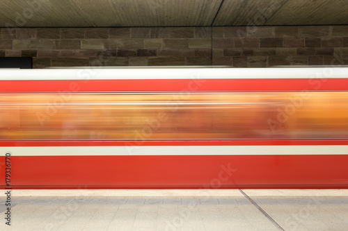 Moving red and white subway in the underground going past