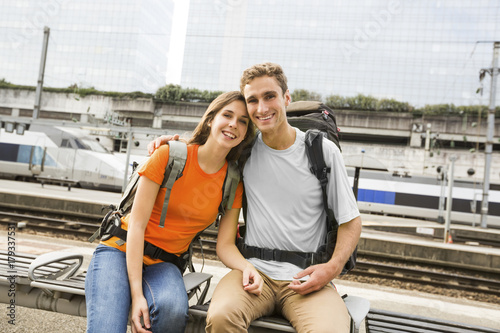 Caucasian couple waiting on bench at train station photo