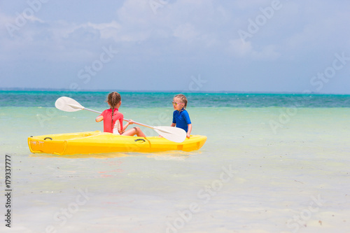 Little adorable girls enjoying kayaking on yellow kayak © travnikovstudio