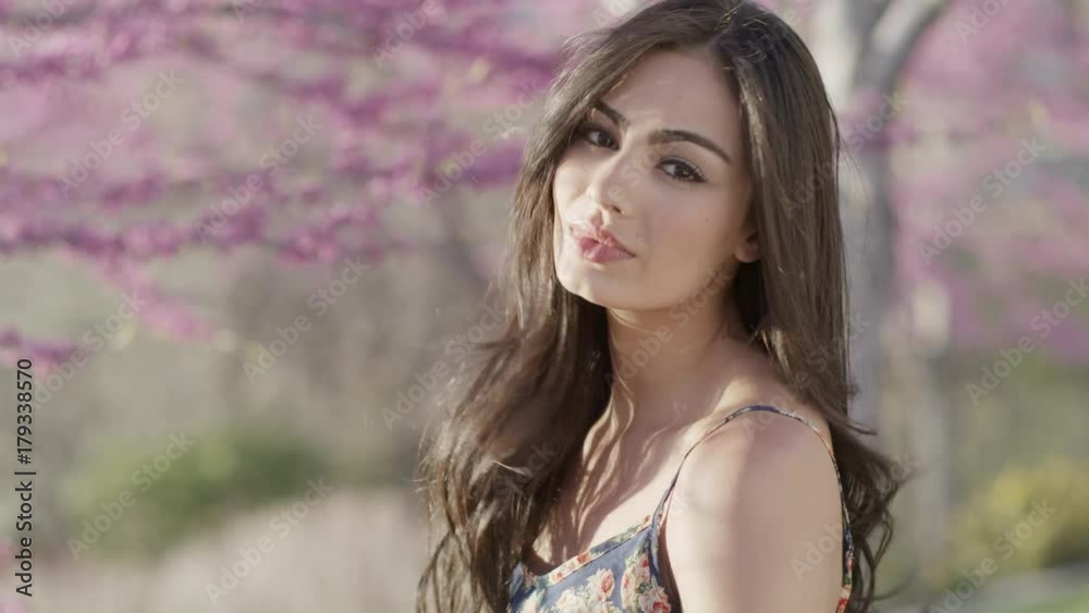 Close up portrait of serious woman standing near flowering trees / Cedar Hills, Utah, United States Close up portrait of serious woman standing near flowering trees / Cedar Hills, Utah, United States