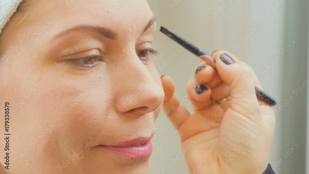 Visagiste paints eyebrows of young woman in beauty salon Visagiste paints eyebrows of young woman in beauty salon