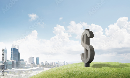 Money making and wealth concept presented by stone dollar symbol on natural landscape