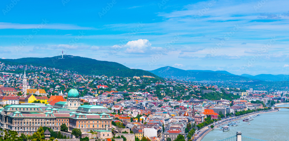 Panoramic cityscape view of hungarian capital city of Budapest from the Gellert Hill. The river Danube. Summertime sunshine day, blue sky and green of trees