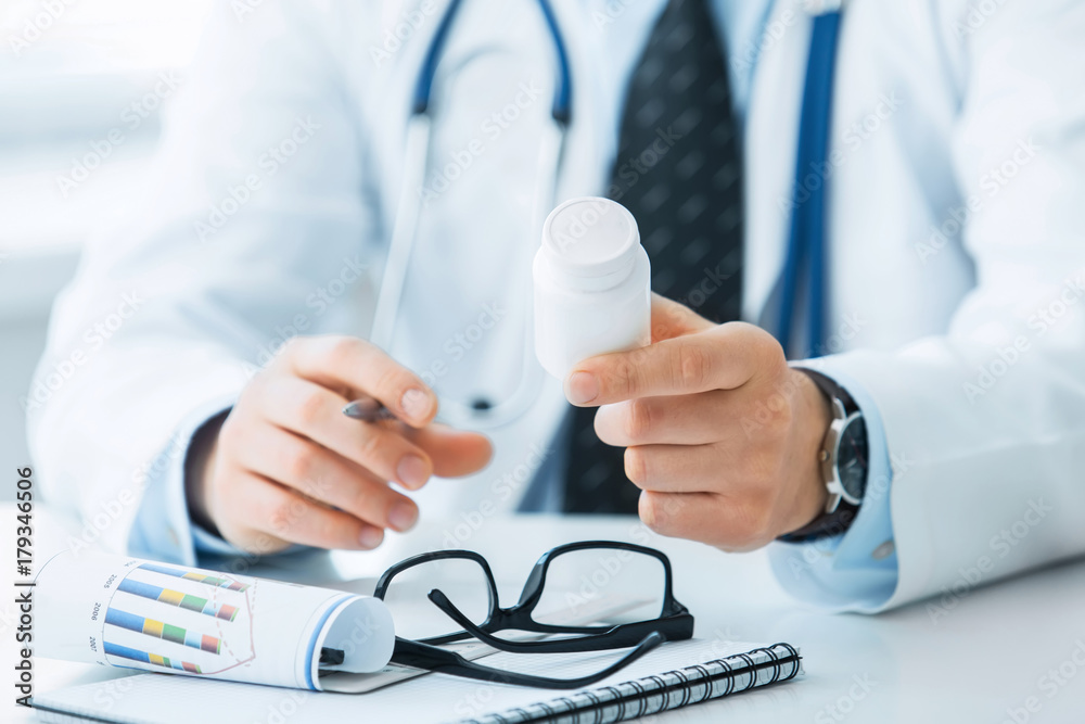 The doctor holds out a vial of pills in the patient's hand The doctor holds out a vial of pills in the patient's hand
