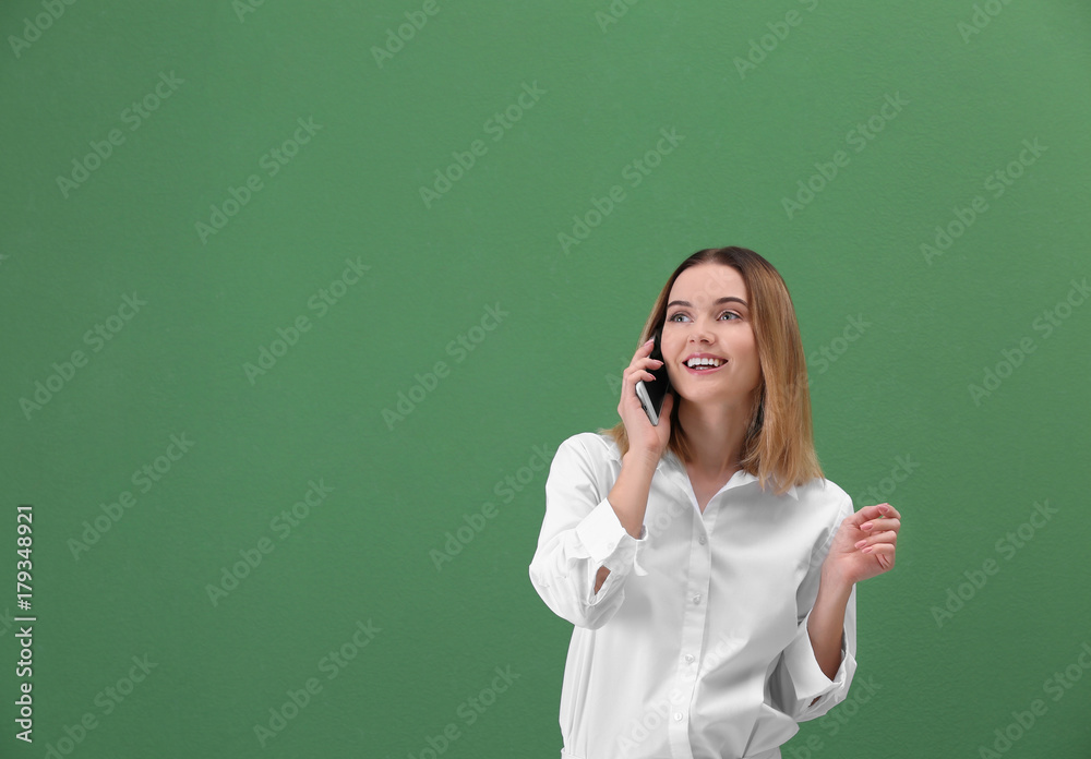 Young woman using cell phone on green background Young woman using cell phone on green background