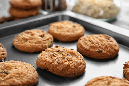 Delicious oatmeal cookies with raisins on tray  close up