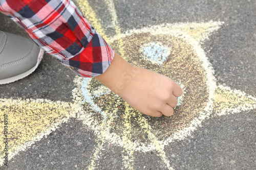 Little child drawing cat with chalk on asphalt, closeup