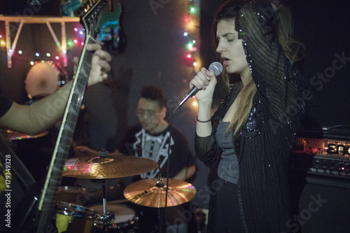 Young woman singing at band rehearsal photo