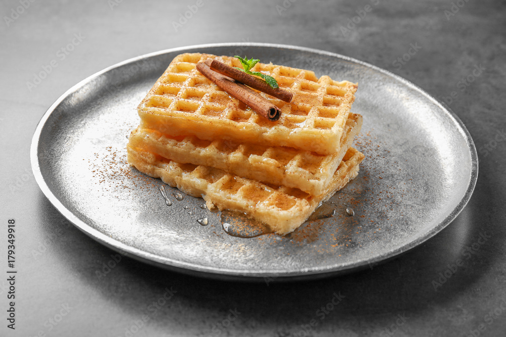 Metal plate with delicious cinnamon waffles on table Metal plate with delicious cinnamon waffles on table