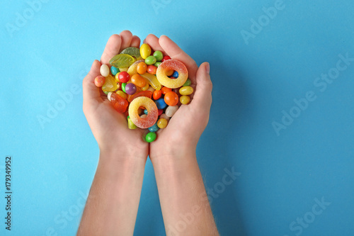 Woman holding colorful candies on blue background