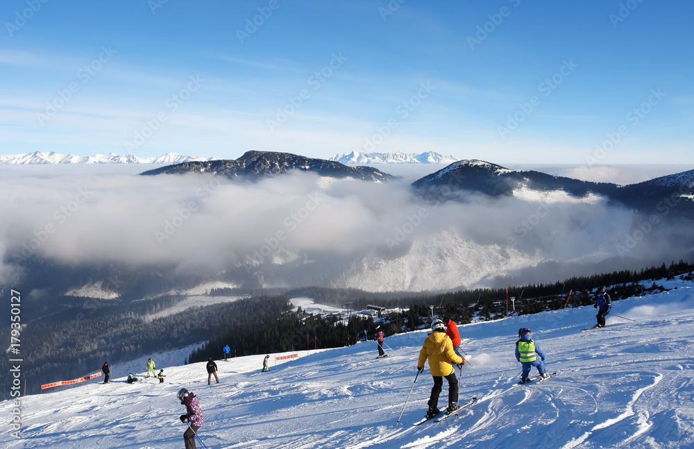 Skiers on the ski slope on a sunny day in the resort of Jasna.