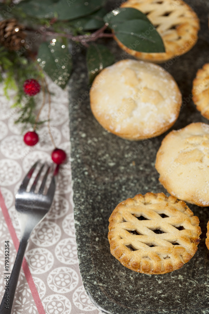 Mince pies on a tray with festive christmas decorations