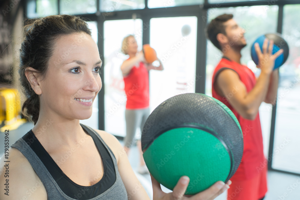 Φωτογραφία strong healthy woman holding heavy medicine ball in gym workout