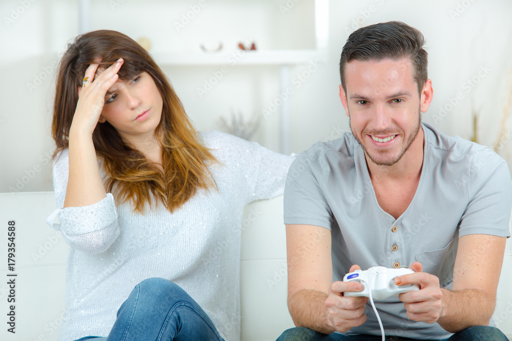 girl is bored by her boyfriend playing video game girl is bored by her boyfriend playing video game