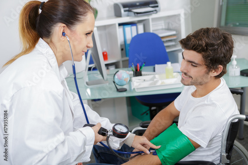 doctor measuring blood pressure of young man