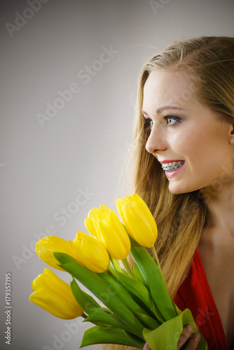 Pretty woman with yellow tulips bunch