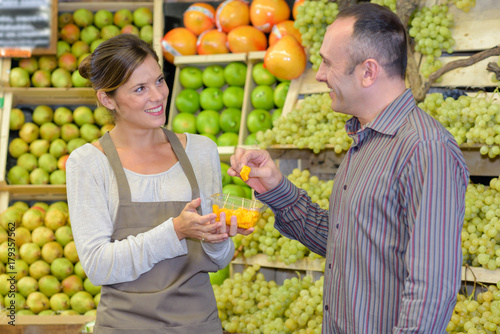 Customer accespting taster in fruit aisle