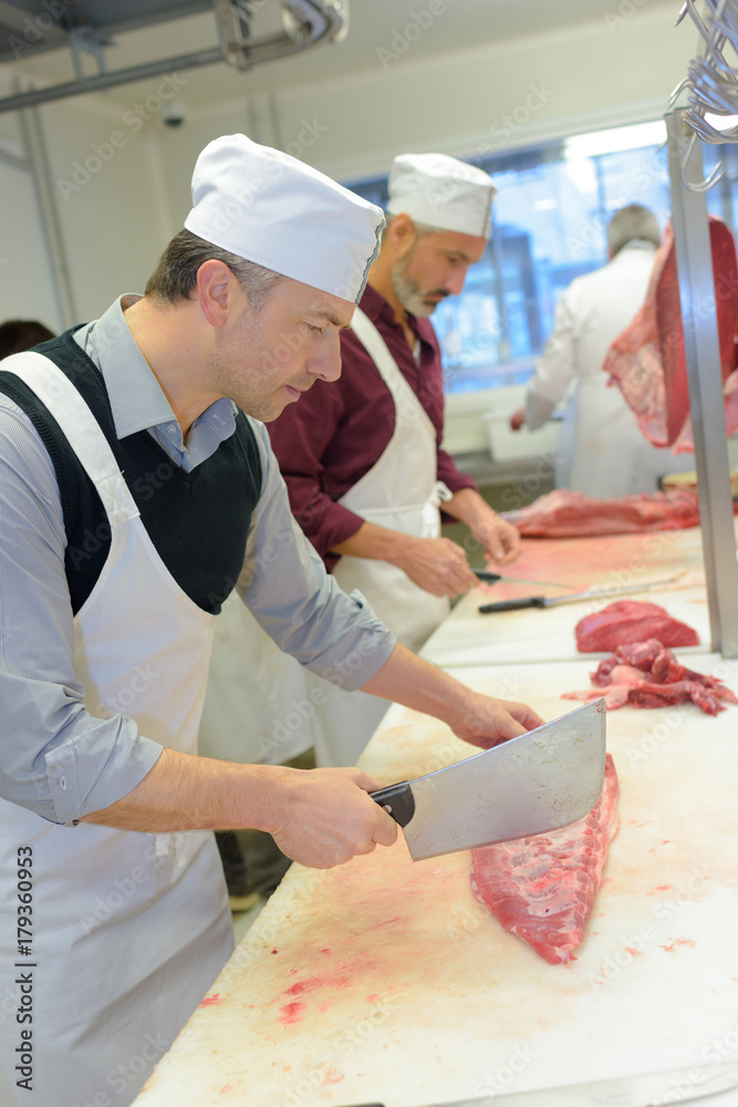 Butchers cutting up meat