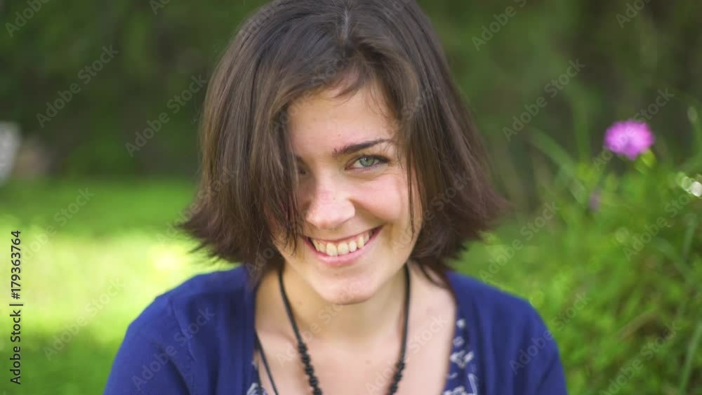 Beautiful young woman in the garden smiling and looking the camera Beautiful young woman in the garden smiling and looking the camera