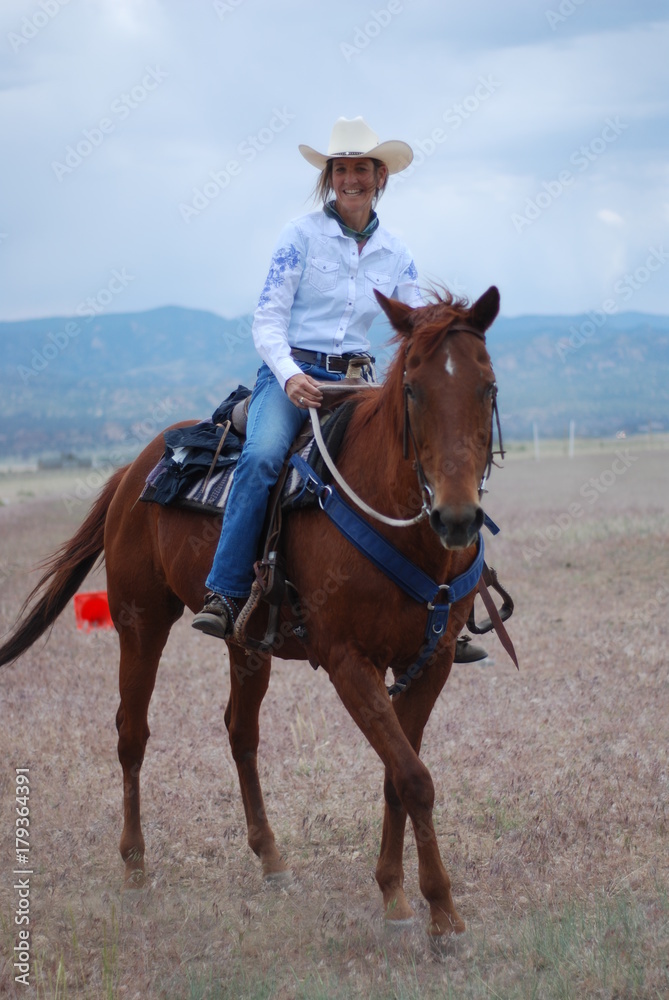 Middle-Aged Cowgirl on Brown Horse Middle-Aged Cowgirl on Brown Horse