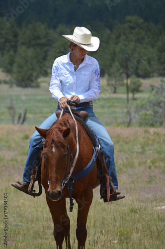 Middle-Aged Cowgirl on Brown Horse