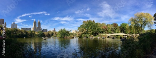 Pond and Bow bridge at Central Park in early fall panorama view