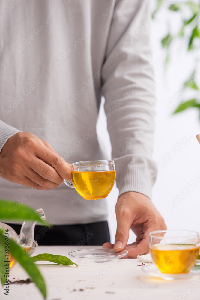 Hand holding cup of tea on wooden table background Hand holding cup of tea on wooden table background