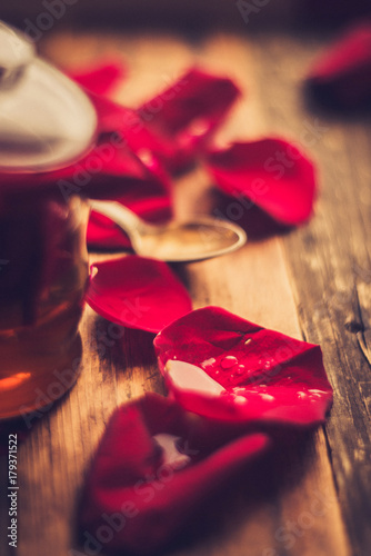 tea made from tea rose petals in a glass bowl on wooden rustic background/ toned image photo