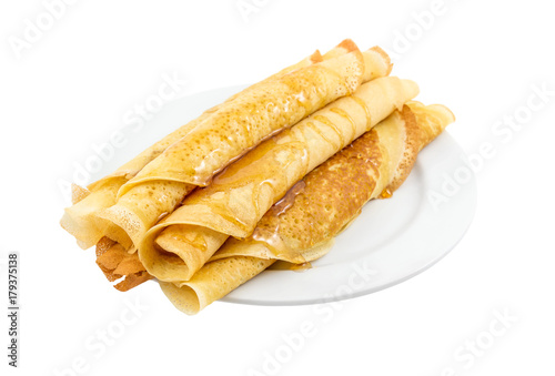 Rolled pancakes with honey on the plate. Isolated on white.