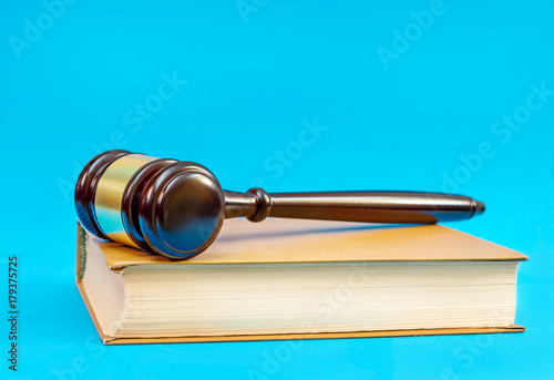 Wooden gavel with book on a blue background. Justice concept.