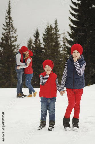 Mother, father and two sons having fun in snow winter