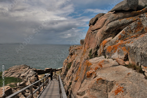 Access to the cliffs of Ccap Prioriño, Ferrol, A Coruña, Galicia, Spain,composition of wooden stairs in a surreal  landscape by the ocean,  photo