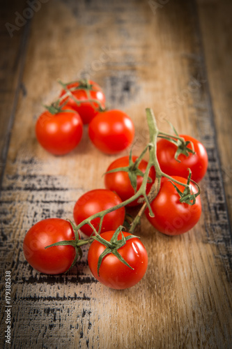 Fresh cherry tomatoes on wooden background