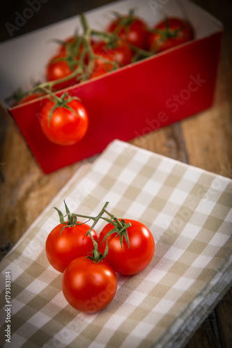 Fresh cherry tomatoes on travel and wooden background © FreeProd