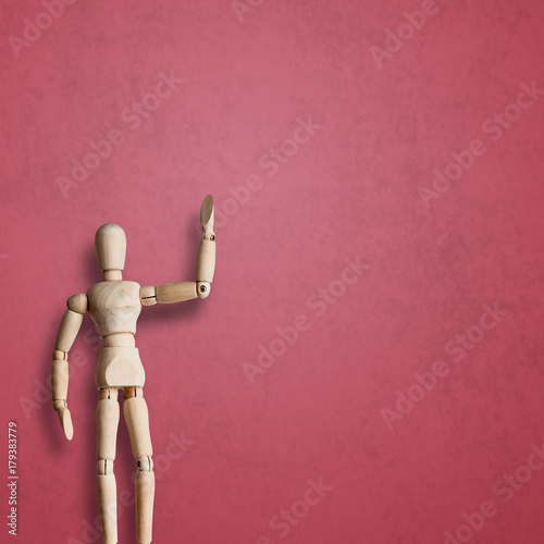 Wooden Mannequin wave hand with greeting on red background with space for your logo photo
