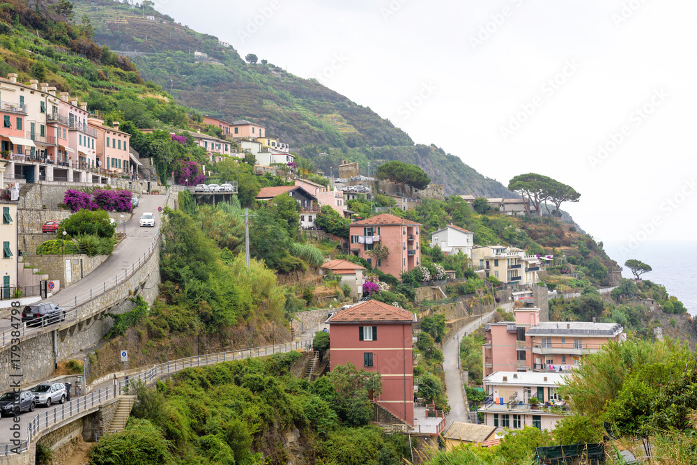 View to city buildings and mountains in a foggy day. Riomaggiore, Italy