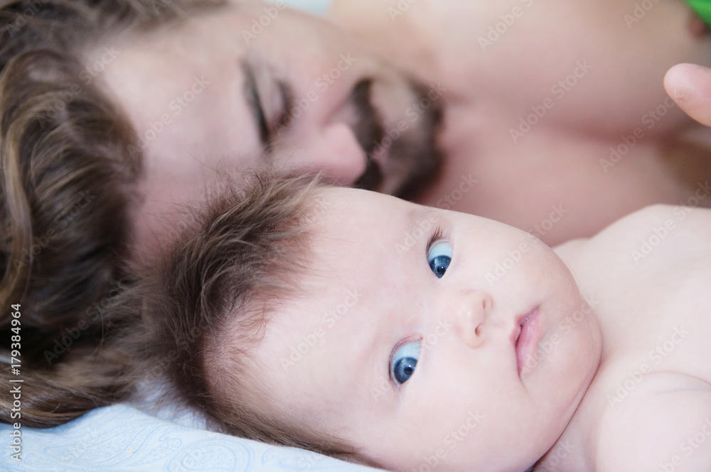 sleeping parent and baby waking up in the morning lying on bed together, happy family sleeping parent and baby waking up in the morning lying on bed together, happy family